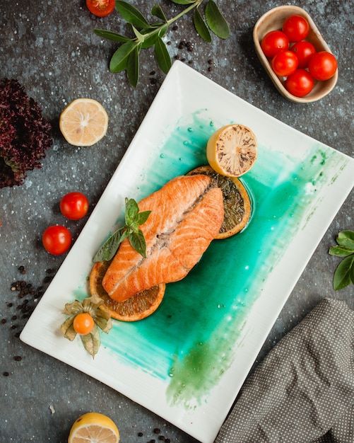 Kostenloses Foto gebratener lachs mit zitronenscheiben und tomaten