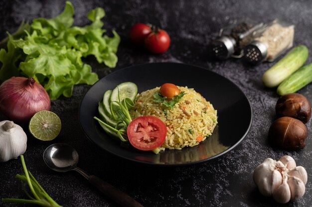 Gebratener Reis mit gehacktem Schweinefleisch, Tomate, Karotte und Gurke auf dem Teller