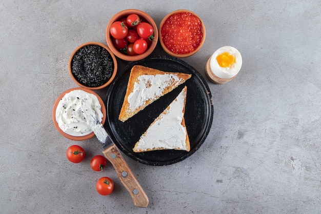 Gebratenes Brot mit gekochten Eiern und roten frischen Kirschtomaten.