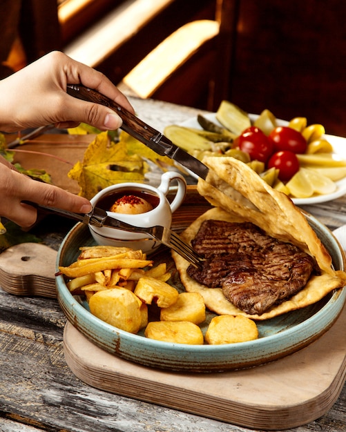 Gebratenes Fleisch im Brot und Pommes