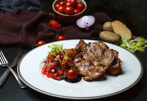 Kostenloses Foto gebratenes fleisch mit gehacktem tomatensalat