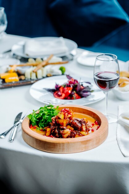 Gebratenes Fleisch und Kartoffeln mit einem Glas Wein