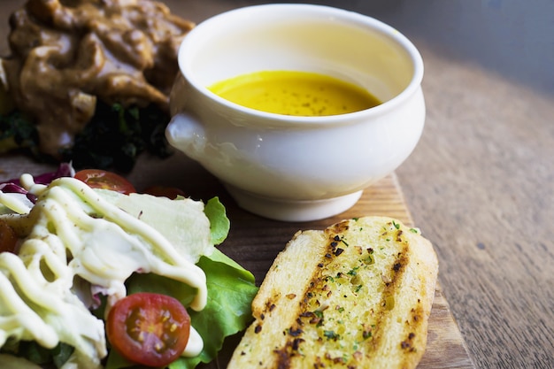 Gebratenes Hähnchen serviert mit Salat und Knoblauchbrot