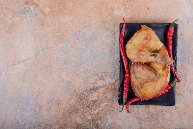 Kostenloses Foto gebratenes hühnerfleisch in einer keramikplatte auf marmor.