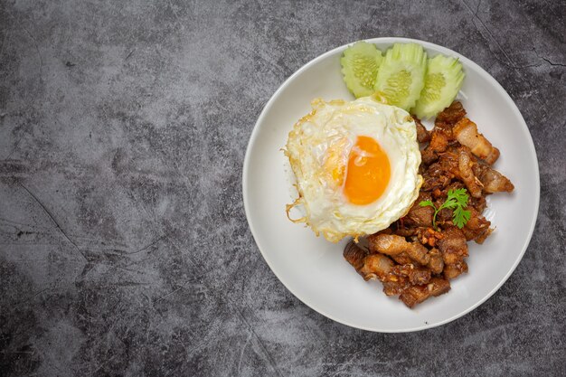 Gebratenes Schweinefleisch mit Knoblauch und Pfeffer, serviert mit Reis und Spiegelei