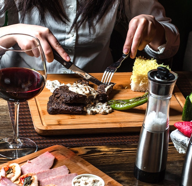 Gebratenes Steak unter Soße mit Reis auf hölzernem Brett