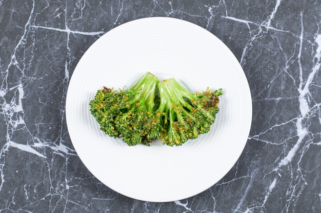 Gedämpfter frischer Brokkoli auf weißem Teller.