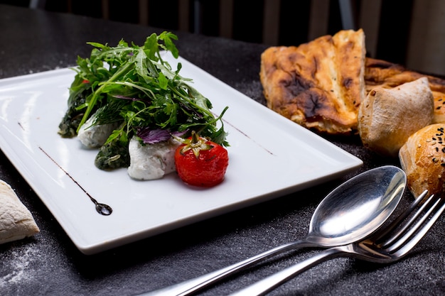 Gedämpfter Spinat mit Seitenansicht der sauren Rucola-Zwiebel-Tomate