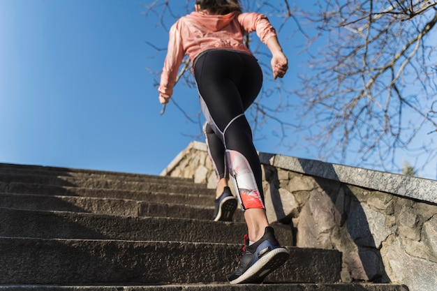 Geeignete kletternde Treppe der jungen Frau im Freien