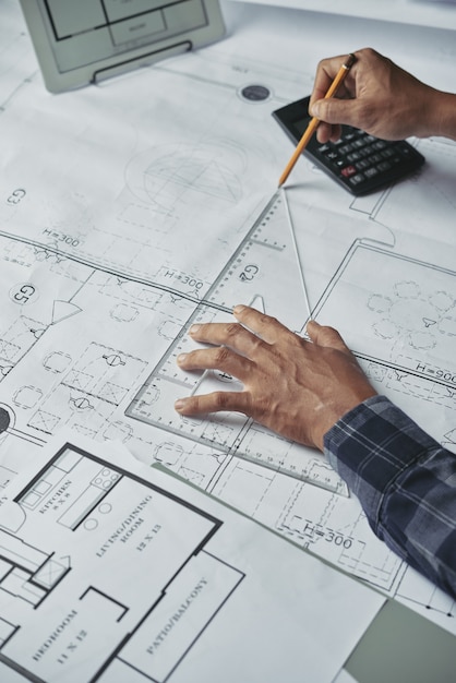 Geerntete Hände des Architekten Plan für das Architekturprojekt