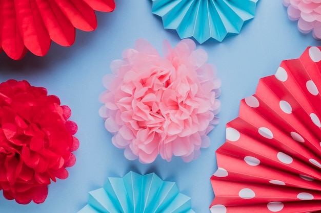 Kostenloses Foto gefälschte schöne dekorative origamipapierblumen auf blauer oberfläche