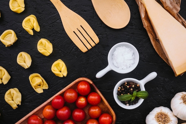 Gefüllte Nudeln und Utensilien in der Nähe von Zutaten kochen