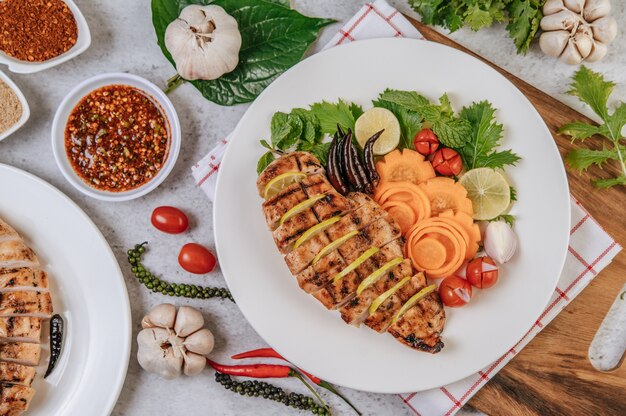 Gegrillte Hähnchenstücke mit Tomaten, Karotten, gebratenem Paprika, roten Zwiebeln, Gurken und Minze.