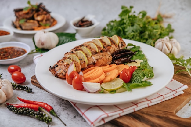 Gegrillte Hähnchenstücke mit Tomaten, Karotten, gebratenem Paprika, roten Zwiebeln, Gurken und Minze.