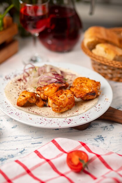 Gegrillte Hühnernuggets, Flügel, Brust mit Zwiebelsalat