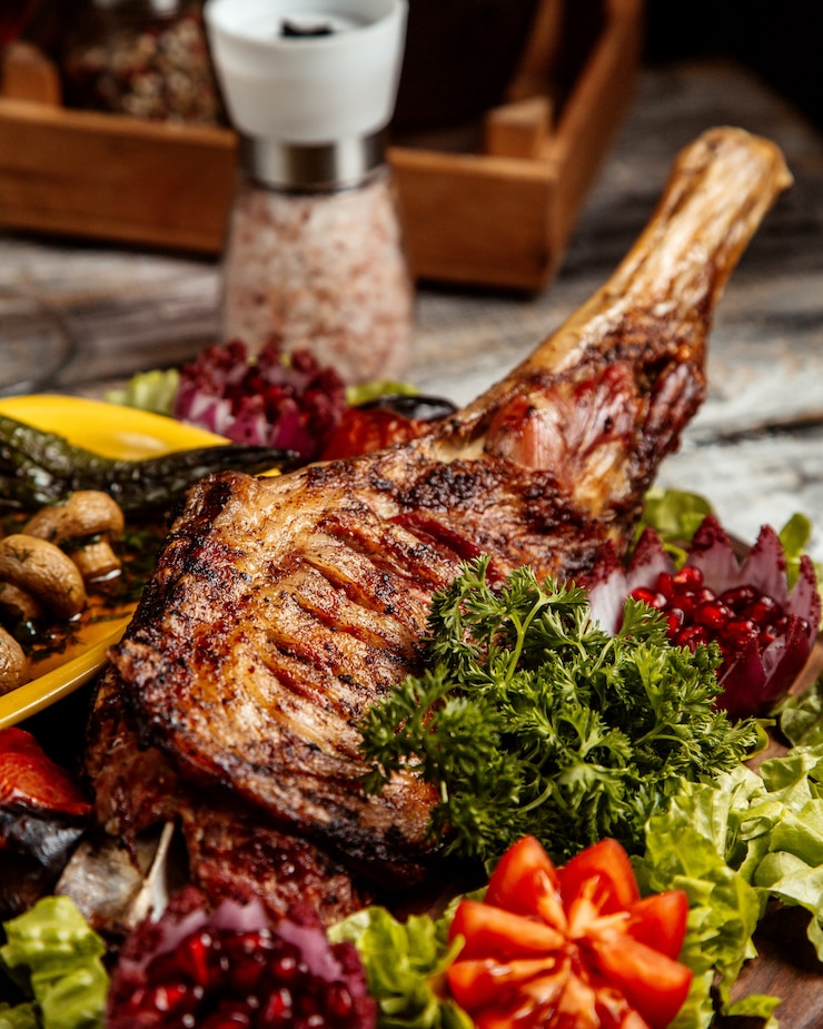 Kostenlose Foto gegrillte lammkeule mit gemüseseitenansicht