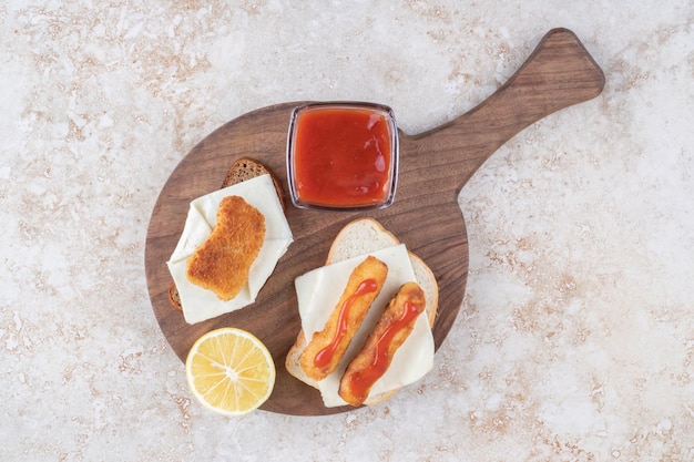 Kostenloses Foto gegrillte wurstsandwiches mit ketchup auf einem holzbrett.