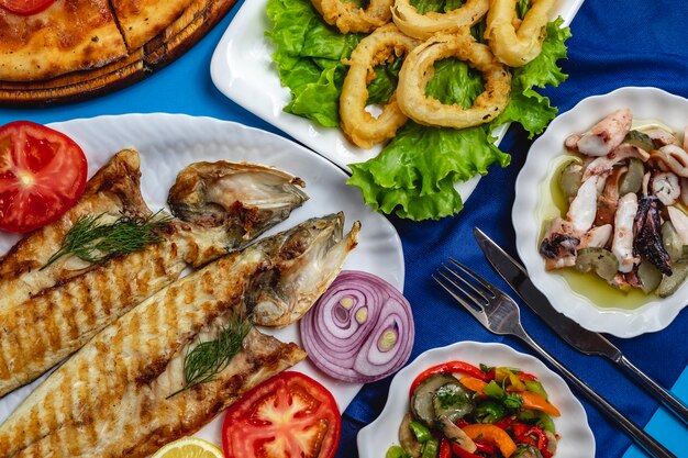 Gegrillter Fisch-Tomaten-Zwiebel-Kalamary-grüner Salat von oben