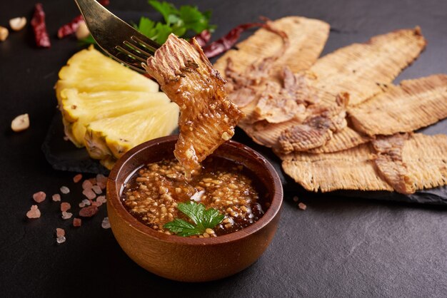 Gegrillter getrockneter Tintenfisch mit Süß-Sauer-Sauce