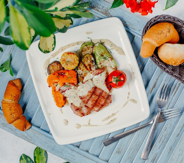 Gegrilltes Fleisch mit gegrilltem Gemüse, Reis und Tomaten.