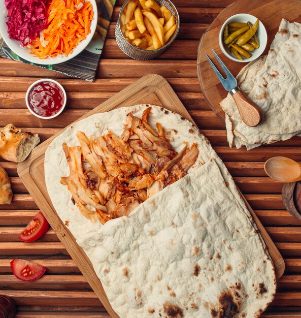 Gegrilltes Fleisch mit Lavash auf einem Holzbrett.