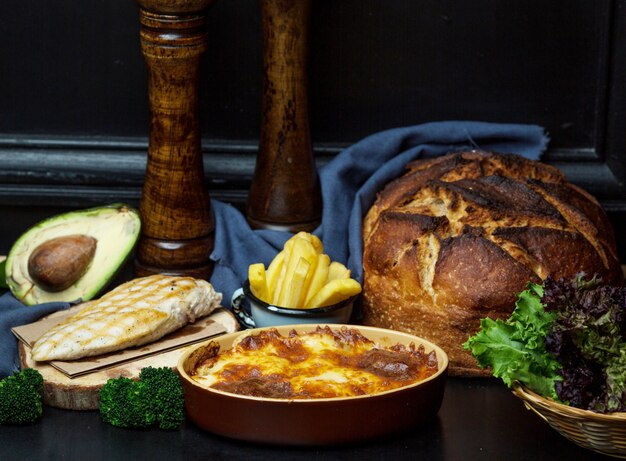 gegrilltes Hähnchenfilet mit Pommes Frites, geschmolzenem Käse und Brötchen