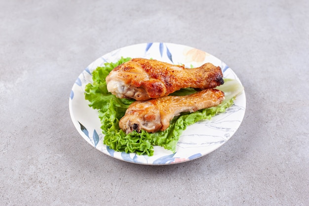 Gegrilltes Hähnchenschenkelfleisch mit Salat auf weißem Teller