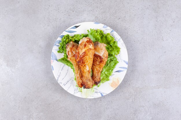 Gegrilltes Hähnchenschenkelfleisch mit Salat auf weißem Teller