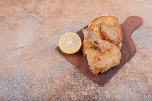 Gegrilltes Hühnerfleisch mit Zitrone auf einer Holzplatte