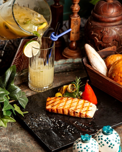 Gegrilltes Lachssteak mit gegrilltem Gemüse Zitronenrosmarin hausgemachte Limonade und Brot auf dem Tisch