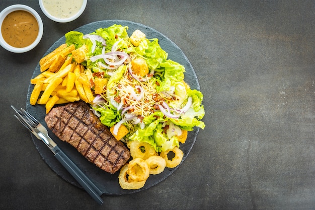 Gegrilltes Rindfleischsteak mit Zwiebelring aus Pommes frites