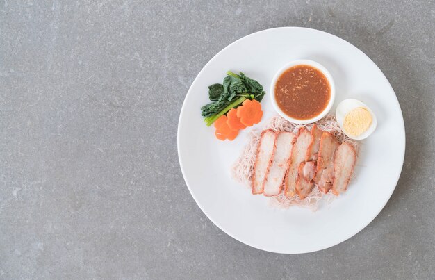 Gegrilltes rotes Schweinefleisch in Sauce mit Vollkornnudeln