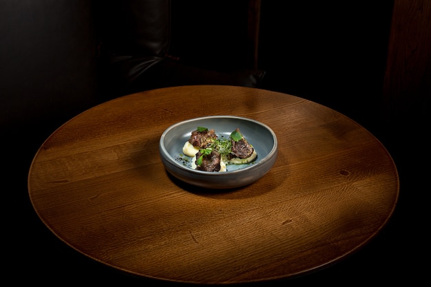 Gegrilltes Steak mit Gemüsepüree auf Teller auf Holztisch.