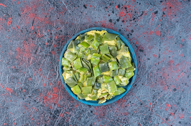 Gehackte grüne Bohnen kochen mit Eiern in einer Servierplatte.