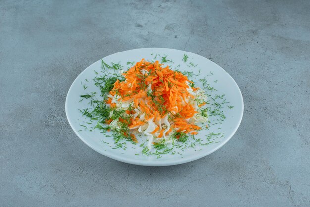 Gehackter Kohl und Karotten auf weißem Teller.
