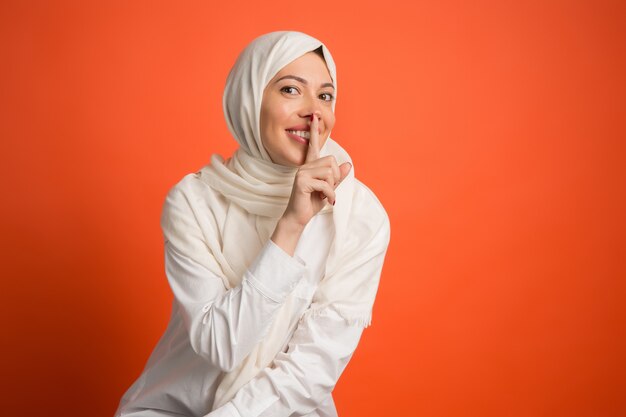 Geheimes Klatschkonzept. Glückliche arabische Frau im Hijab.