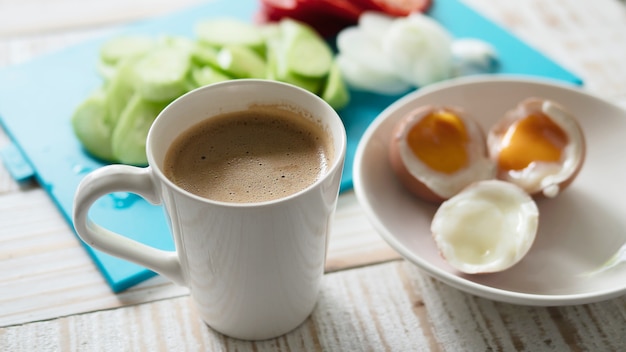 Kostenloses Foto gekochte eier mit frischem gurkensalat und kaffeetassefrühstück stellten - draufsichtfrühstücksnahrungskonzept ein