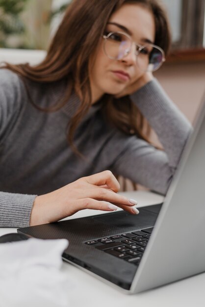 Gelangweilte junge Frau, die von zu Hause aus arbeitet