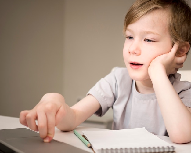 Gelangweiltes Kind, das Online-Klassen hört