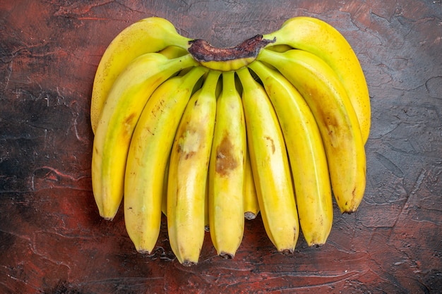 Gelbe Bananen der Draufsicht auf dunklem Hintergrund