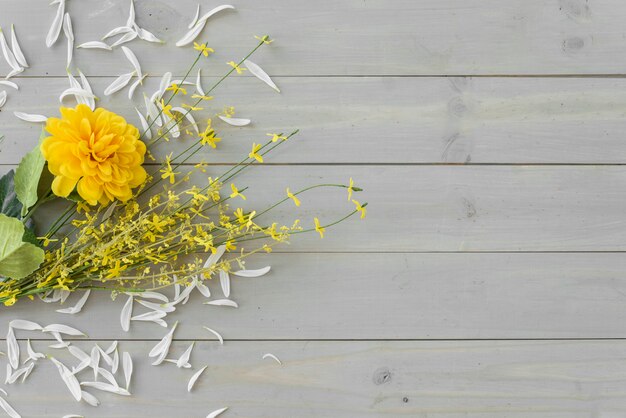 Gelbe Blumen auf grauem hölzernem Schreibtisch