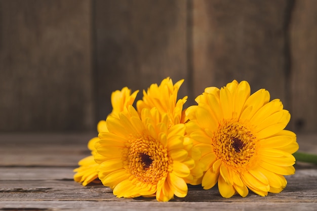 Gelbe Blumen auf Holztisch