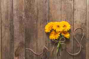 Kostenloses Foto gelbe blumen auf holztisch