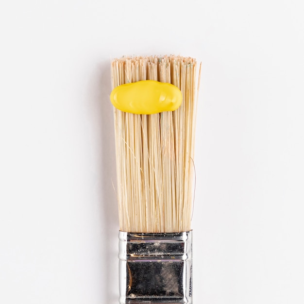 Gelbe Farbe auf Pinsel mit weißem Hintergrund