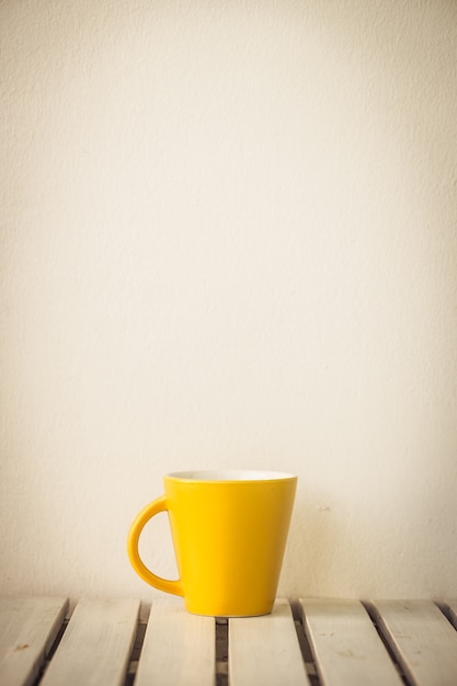 Kostenloses Foto gelbe kaffeetasse auf dem tisch
