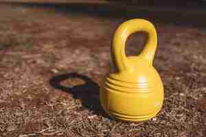 Kostenloses Foto gelbe kettlebell auf dem boden im park