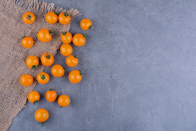 Gelbe Kirschtomaten isoliert auf blauer Oberfläche