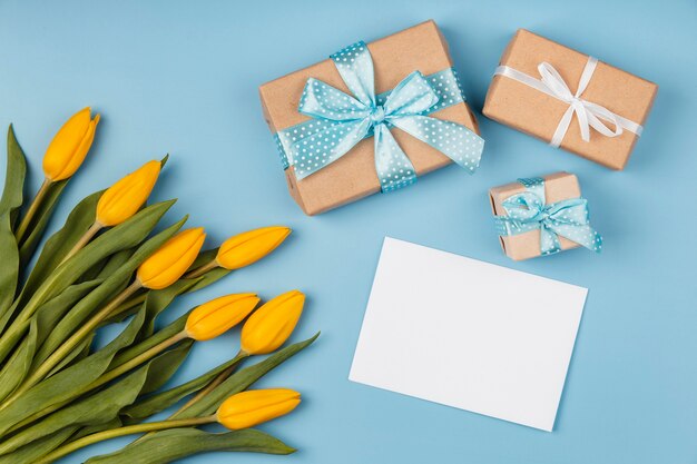 Gelbe Tulpen mit leerer Karte und Geschenken