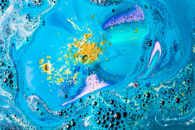 Gelbe und blaue Badebombenblase lösen Hintergrund auf
