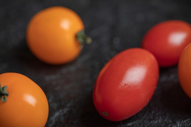 Gelbe und rote Kirschtomaten auf Schwarz.